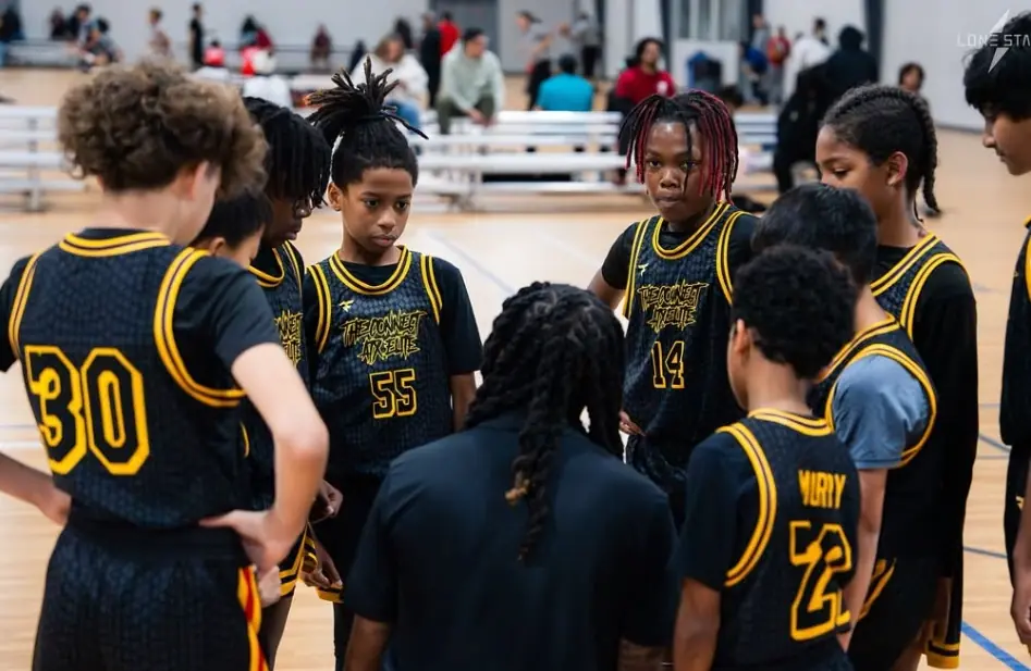 Connect ATX Elite athletes gathered in a courtside huddle